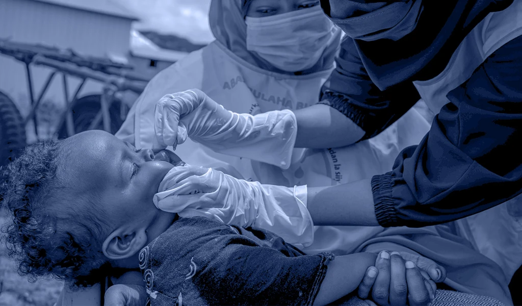 young child being held receiving oral vaccination 
